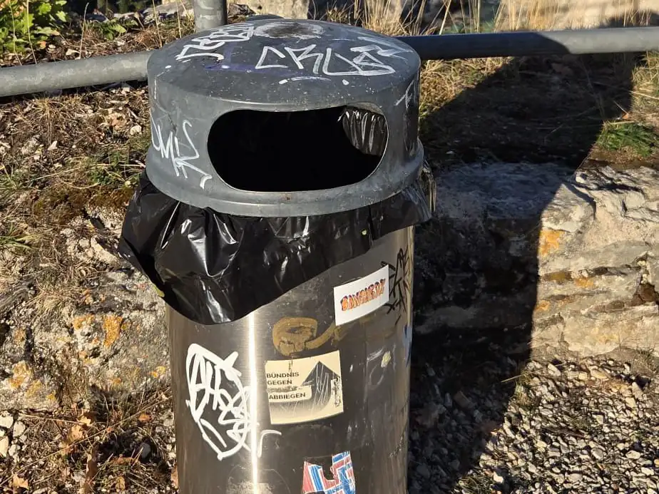 Ein Abfalleimer mit Graffiti und Aufklebern, nur fünf Meter vom Fundort entfernt